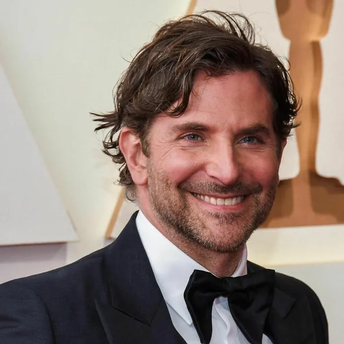 Smiling male celebrity in a tuxedo at an awards event, representing smartest celebrities known for talent and intelligence.