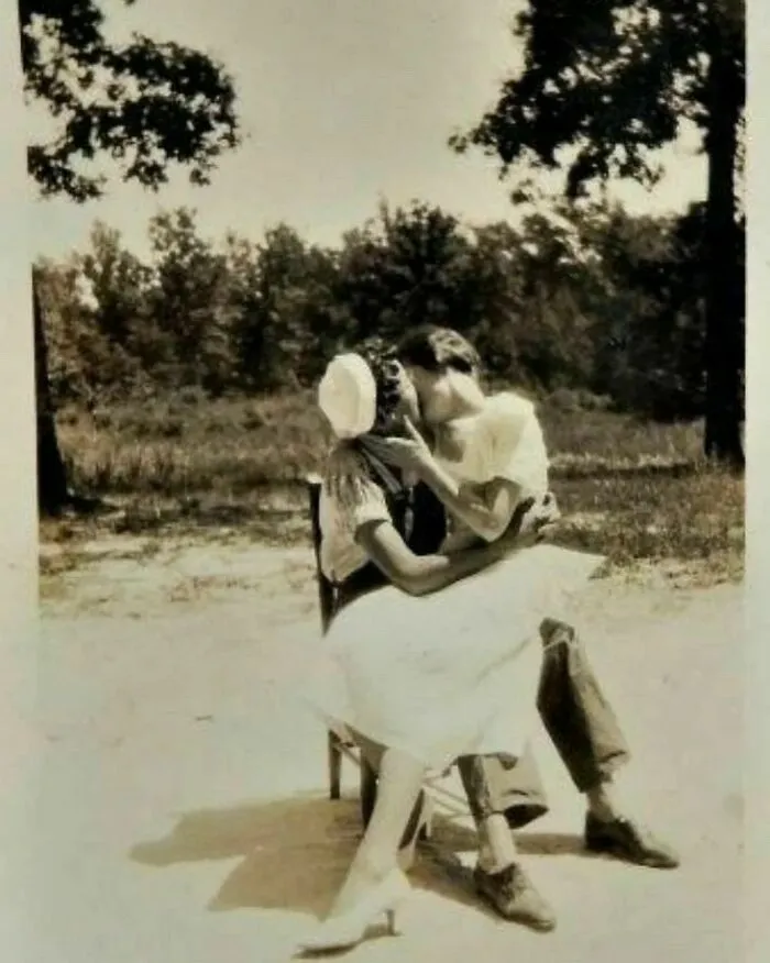 ¡Fotografía de dos mujeres besándose con la leyenda "Um-m! ¡Ese beso! ¡Supongo que todavía te quiero! Simplemente no puedo evitarlo", 1930