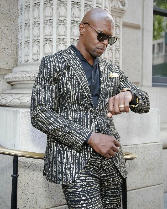 Man wearing a patterned suit and sunglasses standing outdoors, representing the smartest celebrities known for their intelligence.