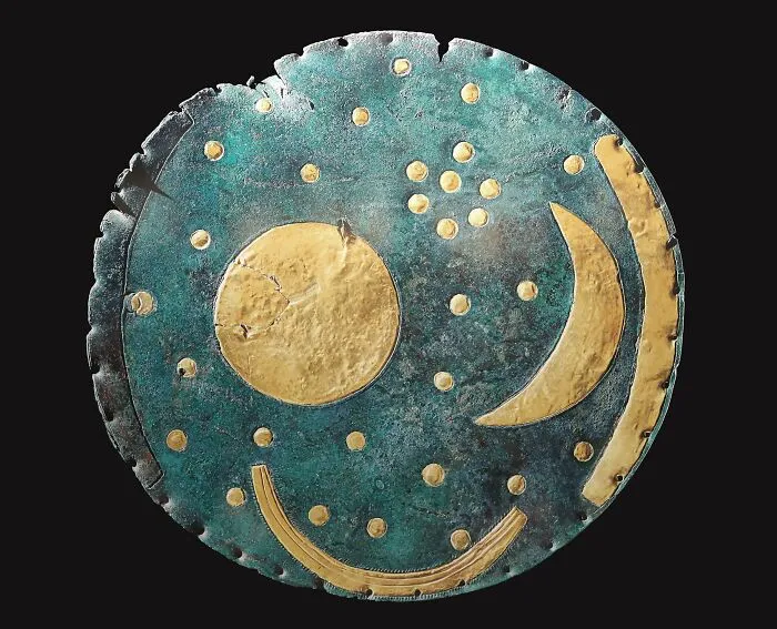 Ancient artifact with gold celestial symbols revealing historical information on a bronze disc.