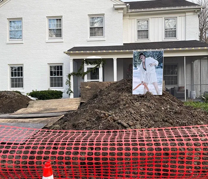 Christmas humor with a funny photo on a construction site in front of a decorated house.