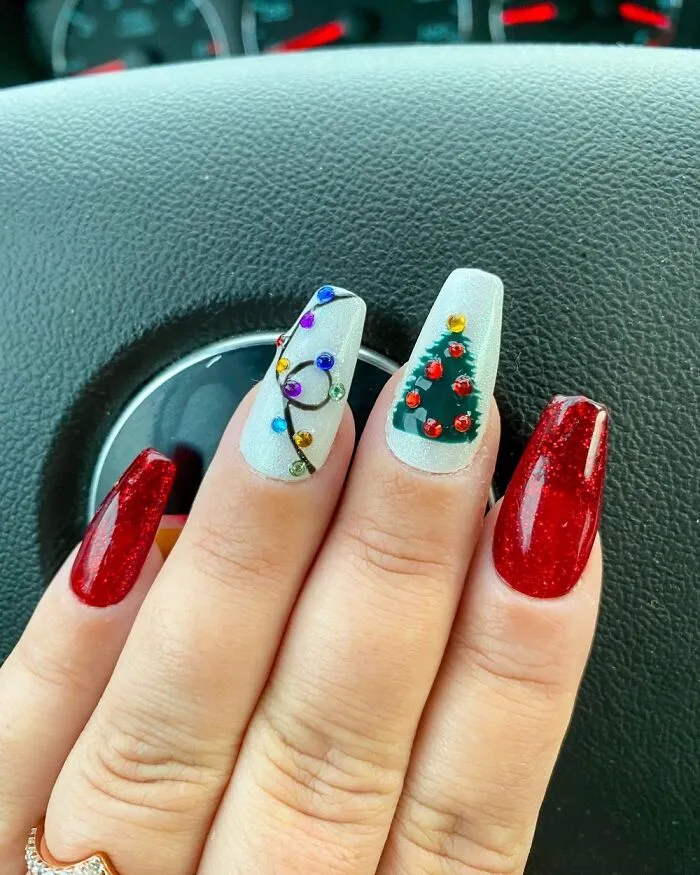 Creative Christmas nail art featuring a hand-painted holiday tree and lights.