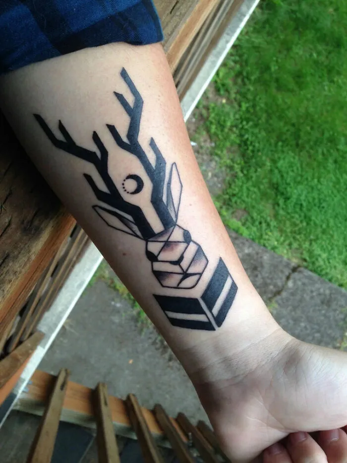 Minimalist tattoo featuring geometric deer design on a forearm, showcasing aesthetically pleasing ink art.