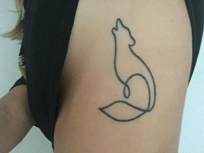 Minimalist tattoo of a stylized fox on a person's arm, featuring clean lines and a simple design.