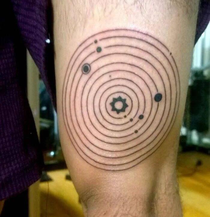 Minimalist tattoo with concentric circles and dots on arm, showcasing aesthetically pleasing design.