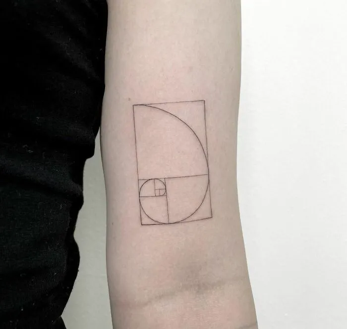 Minimalist tattoo of a Fibonacci spiral on a forearm, showcasing simple yet aesthetically pleasing design.