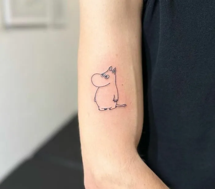Minimalist tattoo of a cartoon character on a person's arm, showcasing its aesthetically pleasing design.