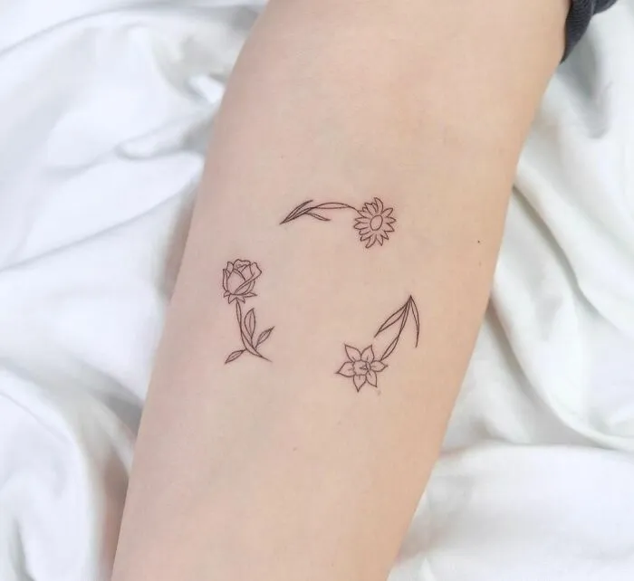 Minimalist tattoo of delicate floral designs on skin, showing aesthetically pleasing simplicity.