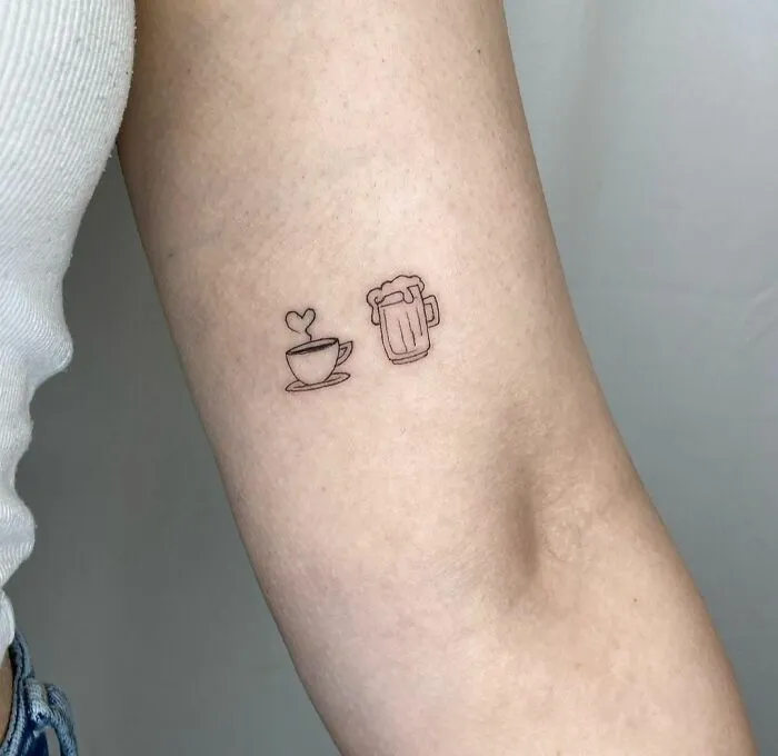 Minimalist tattoos of a heart-shaped coffee cup and a beer mug inked on an arm.