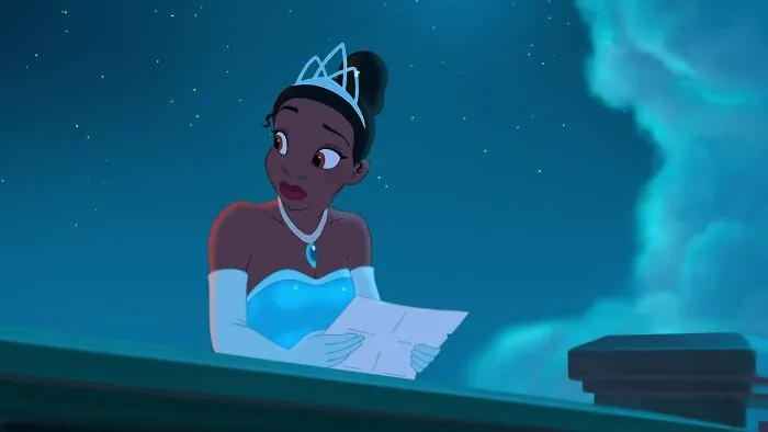 Female cartoon character in a tiara gazing at a paper under a starry sky.