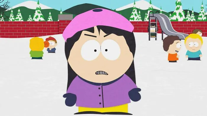 Female cartoon character wearing a pink hat and purple coat, standing in a snowy playground with other kids.
