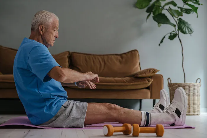Old man doing exercise on a yoga mat 