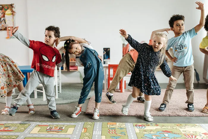 Multiple kids exercising in the kindergarten