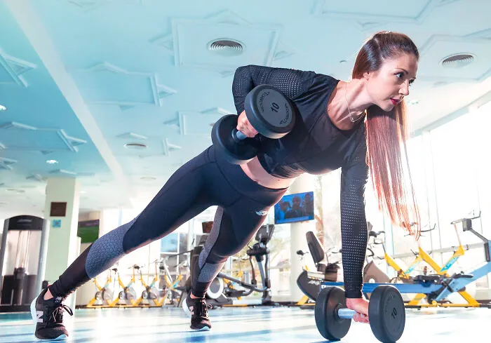Woman doing exercises using dumbbells 