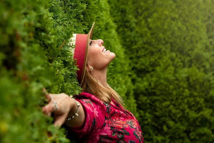 Woman touching a tree and looking up 