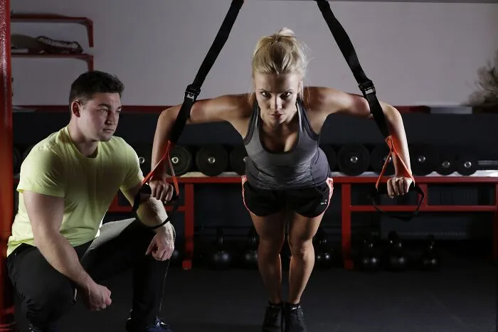 Woman doing an exercise and a man is watching 