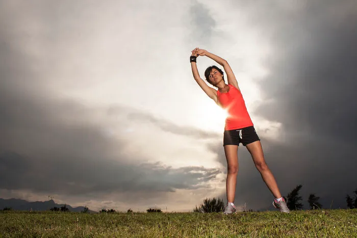 Woman stretching outside on the grass 