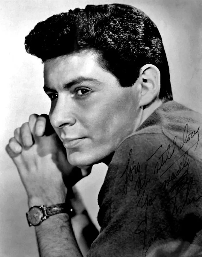 Eddie Fisher wearing a watch, posing thoughtfully in a black and white photo of famous people married multiple times.