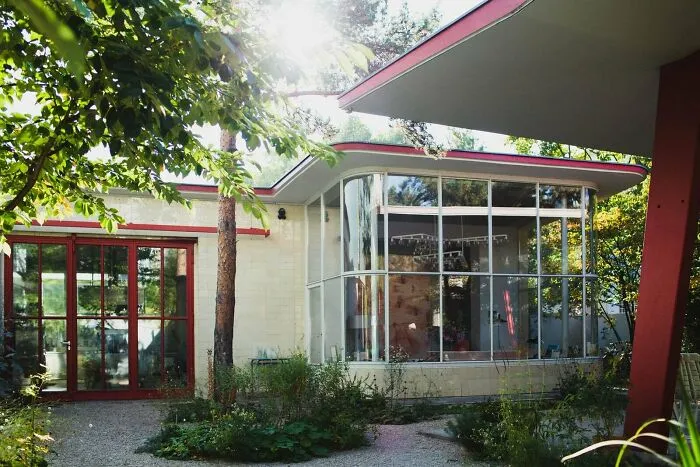 Mid-century modern building conversion surrounded by lush greenery.