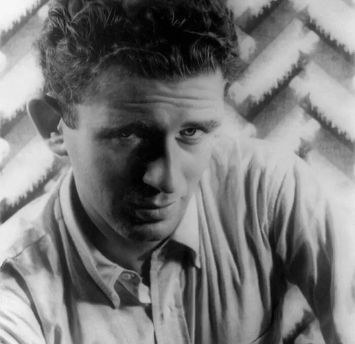 Norman Mailer wearing a shirt in a black and white portrait, one of the famous people who got married multiple times.