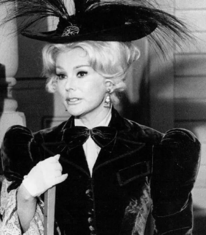 Eva Gabor wearing a black feather hat and vintage outfit, one of the famous people who got married multiple times.