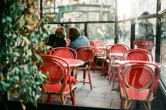Man and a woman sitting besides the desk and talking 