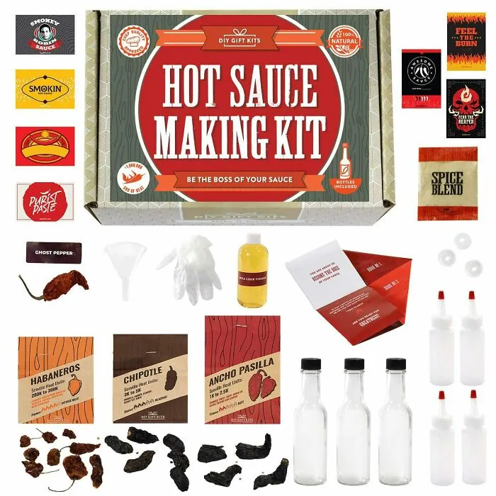 Hot sauce making kit gift with spices, bottles, and chili peppers for Valentine's Day love and affection.