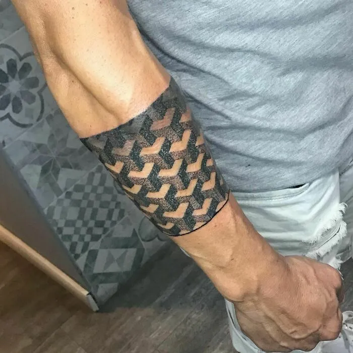 Optical illusion tattoo on forearm with geometric, mind-bending design.