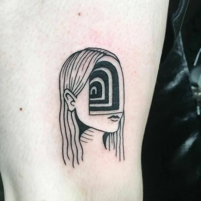 Optical illusion tattoo design featuring a woman's face with abstract pattern.