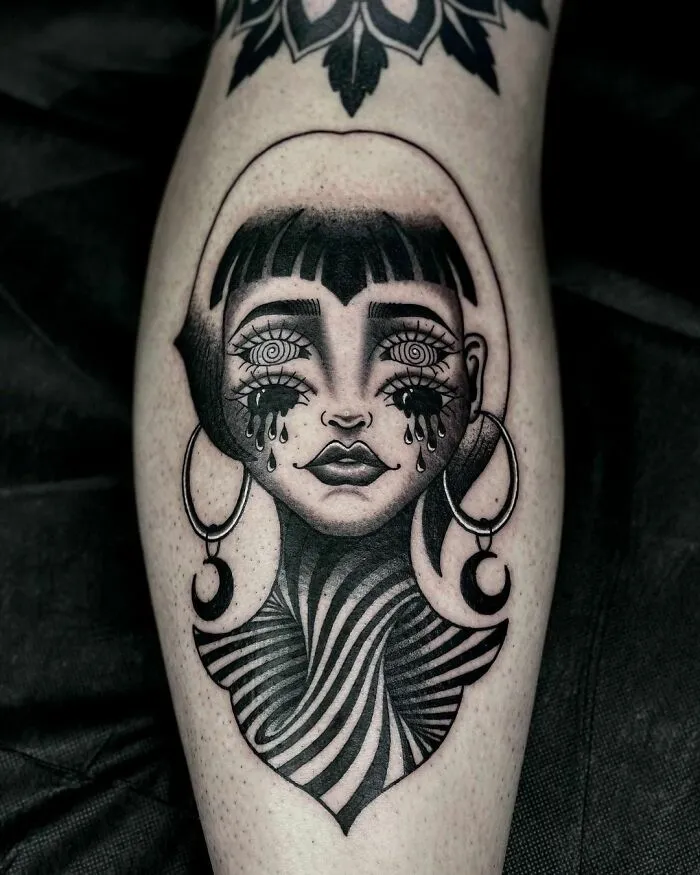 Optical illusion tattoo design featuring a surreal woman's face with teardrop eyes and a swirling neck pattern.