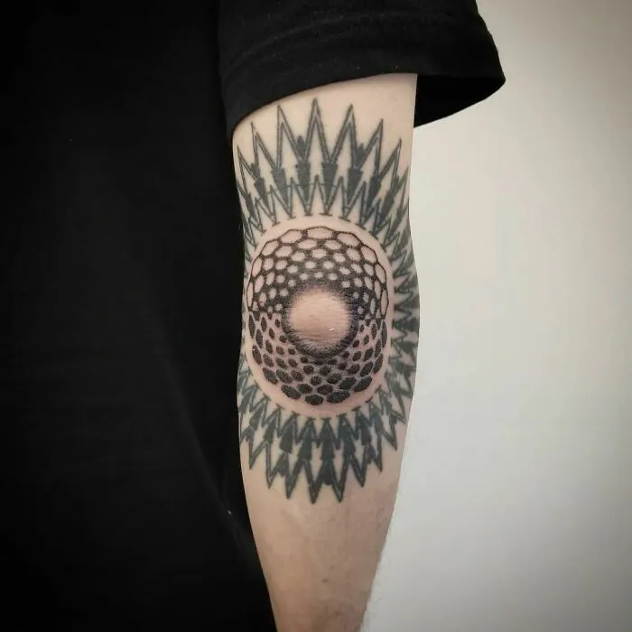 Optical illusion tattoo on forearm, featuring geometric patterns and a 3D effect.