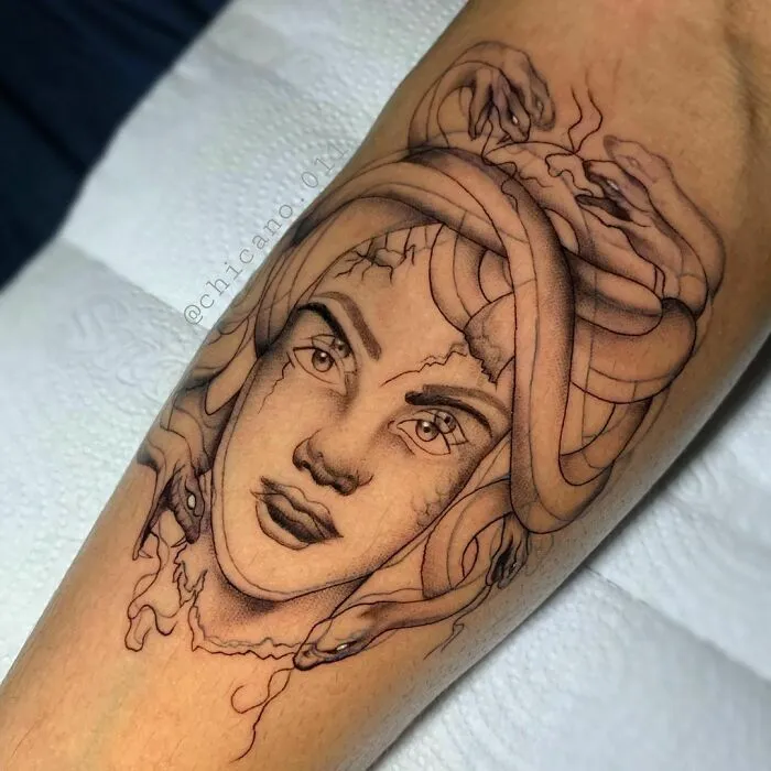 A Medusa-themed optical illusion tattoo design on a forearm, featuring snakes as hair.
