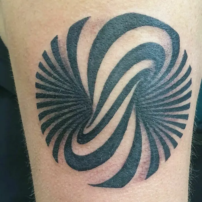 Optical illusion tattoo with swirling, eye-catching design on skin.