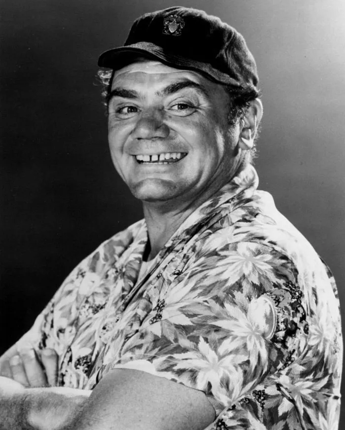 Ernest Borgnine wearing a baseball hat and floral shirt, smiling for a portrait of famous people married multiple times.