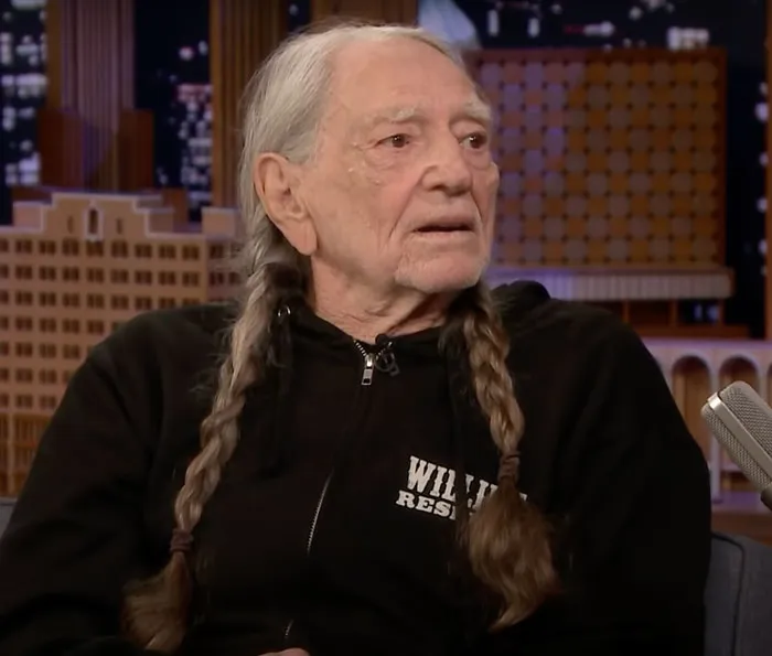 Willie Nelson wearing a black zipped hoodie, featured among famous people who got married multiple times.