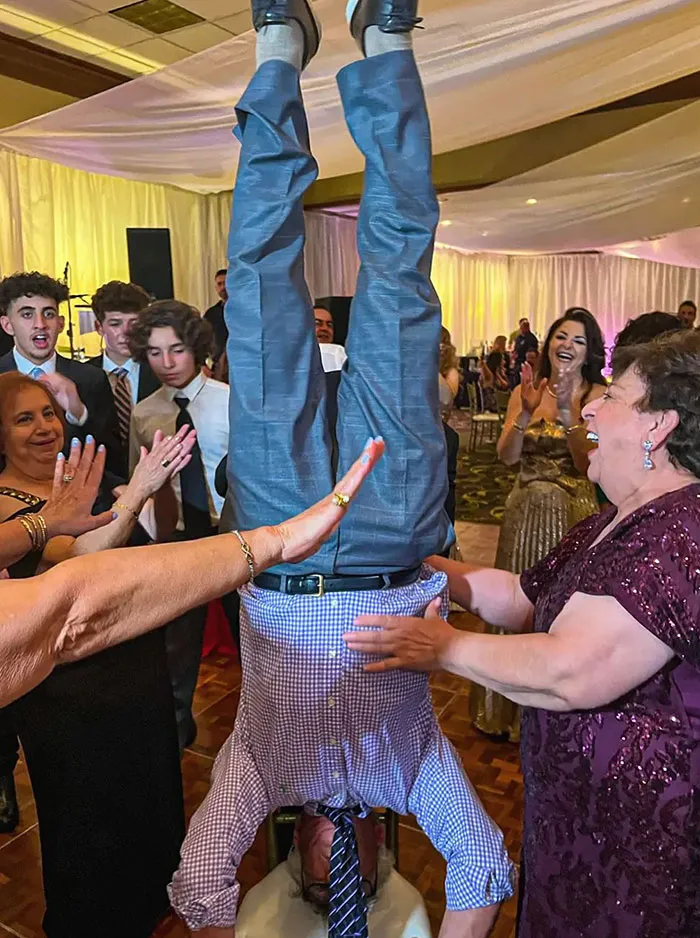 No conozco una foto de boda más perfecta que esta: mi padre, parado de cabeza en la pista de baile rodeado de su familia aplaudiendo  