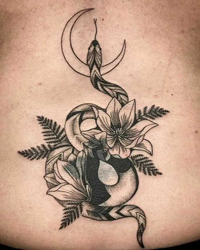 Nature tattoo featuring a snake, flowers, and crescent moon, symbolizing the wonders of Mother Earth.