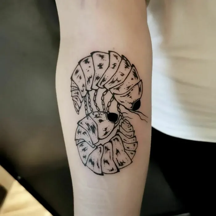 Nature tattoo featuring abstract insect design on forearm.