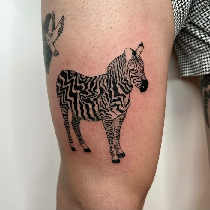 Zebra tattoo on a person's arm with realistic stripes, celebrating the wonders of nature.
