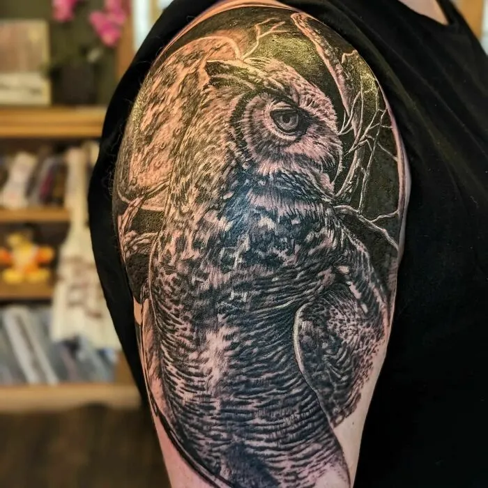 Owl tattoo on arm, showcasing detailed nature art.