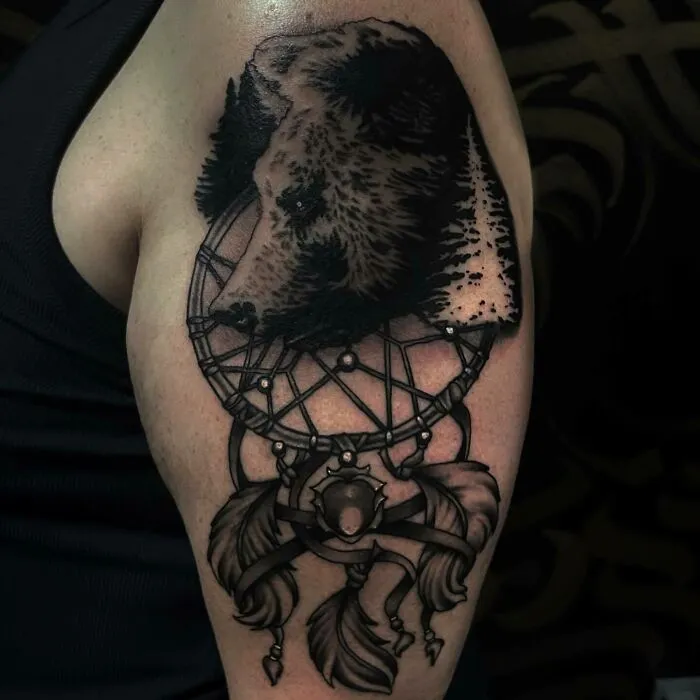 Bear tattoo with dreamcatcher design, celebrating nature's wonders.