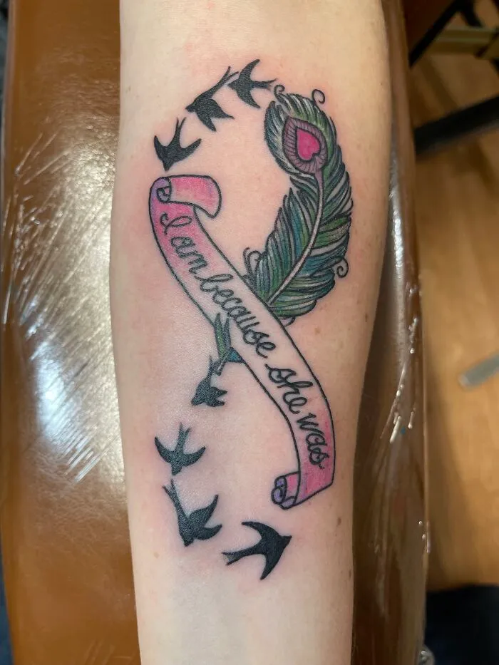 Peacock feather with text tattoo includes birds and scroll design, exemplifying creative word tattoos for inkspiration.