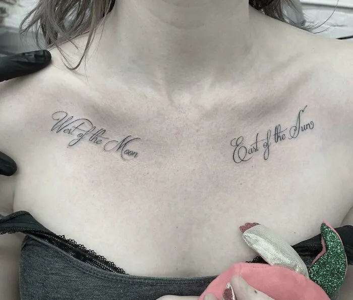 Creative word tattoos on collarbone reading "West of the Moon" and "East of the Sun" for inkspiration.