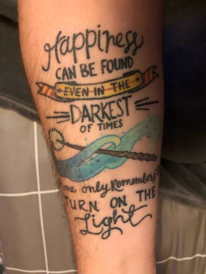 Creative word tattoo featuring an inspirational quote in a decorative script with colorful accents.