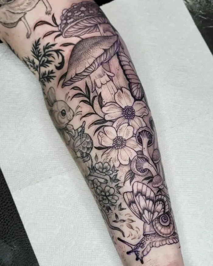 Nature tattoo featuring mushrooms, flowers, and a snail on an arm.