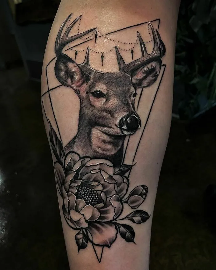 Deer and flower nature tattoo on forearm, featuring intricate details and geometric elements.