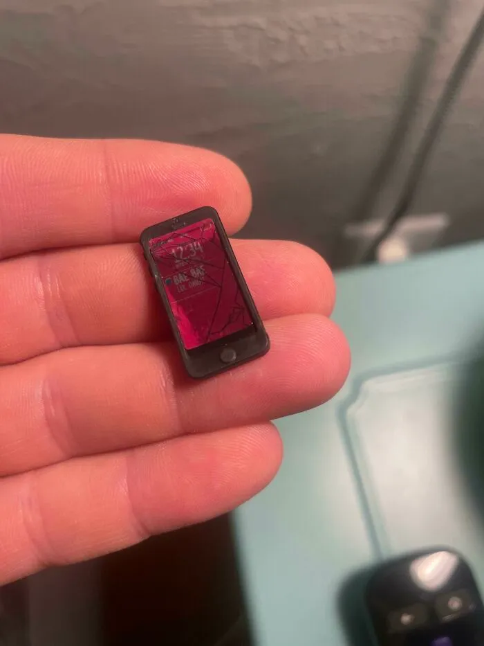 Una muñeca viene con un teléfono diminuto que tiene una pantalla rota diminuta