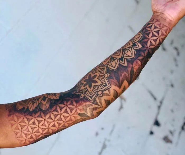 Arm with geometric tattoo designs showcasing intricate shapes and forms with creative patterns.