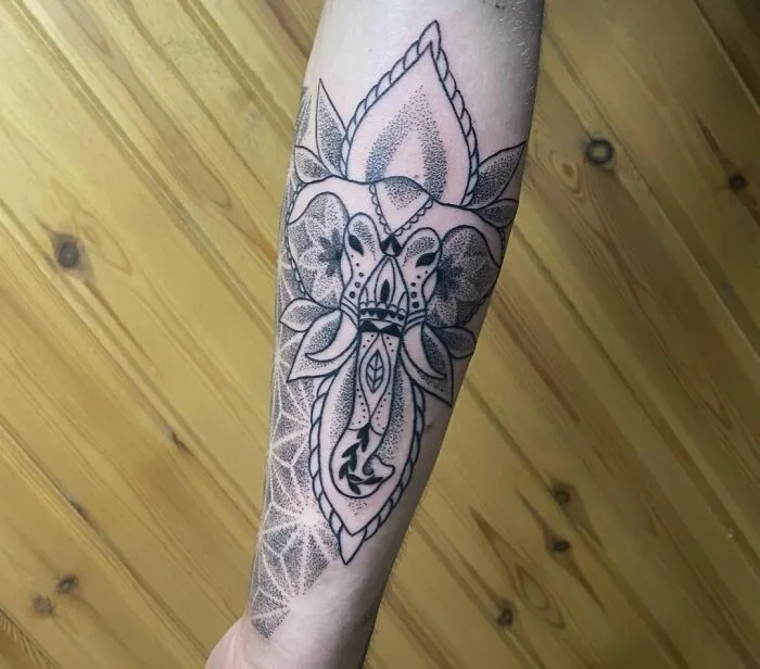 Geometric tattoo design on forearm featuring intricate shapes and forms.