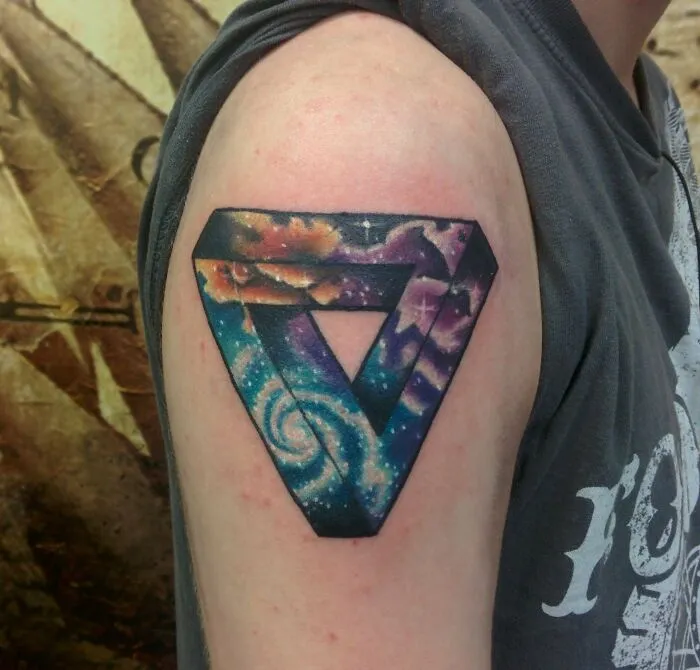 Geometric tattoo featuring a colorful galaxy design with shapes on an arm.